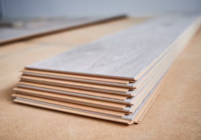 Stack of laminate wooden planks on the floor.